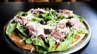 Pizza especial de la casa rucula y prosciutto